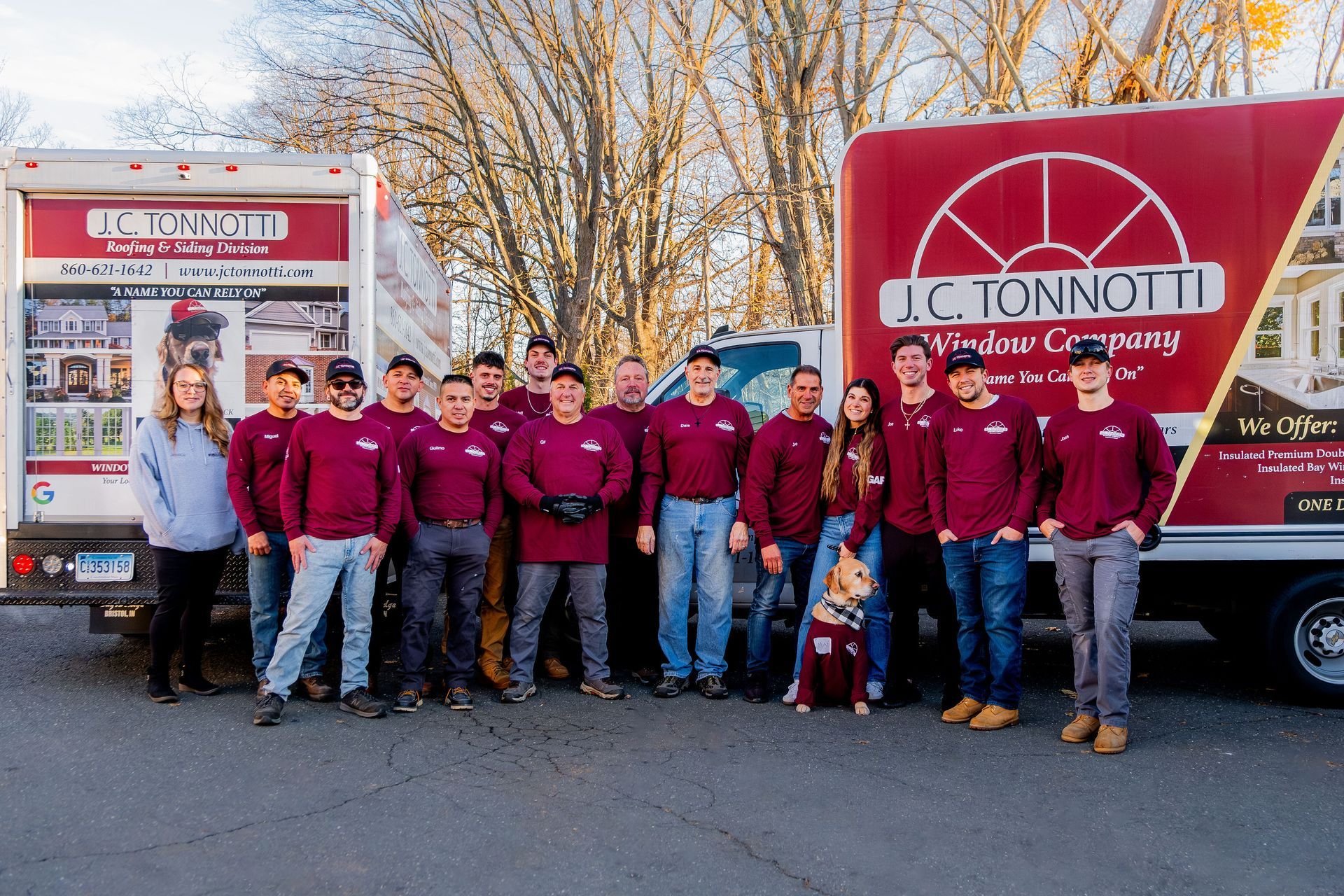 A group of people are posing for a picture in front of a truck of jc tonnotti