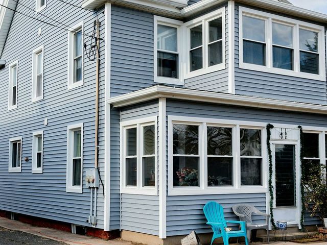 A blue house with a blue chair in front of it.