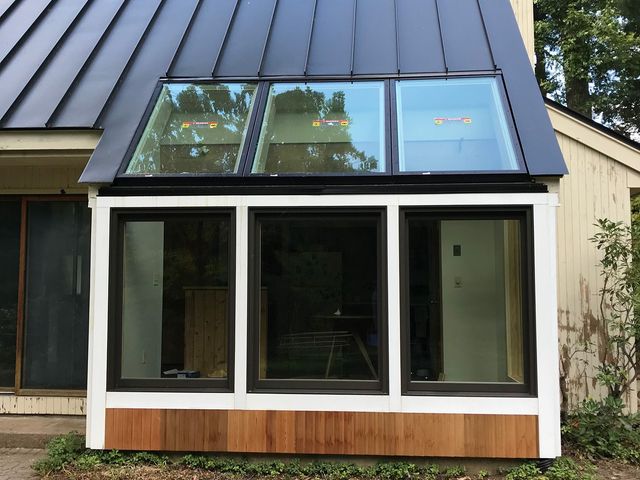 A house with a black roof and three windows