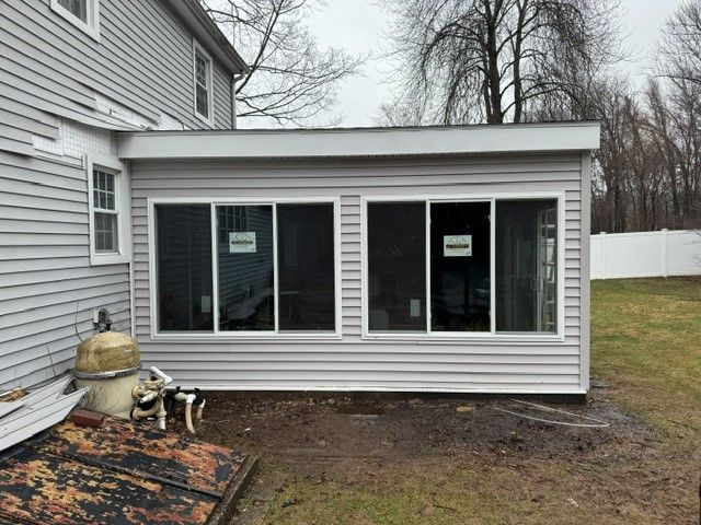 A sunroom is being built on the side of a house.