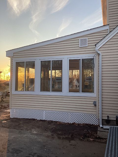 A house with a sun and patio room on the side of it