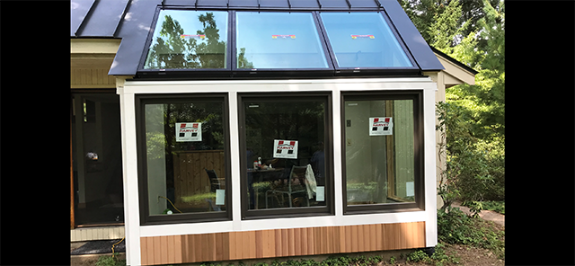 A sun and patio room  with a lot of windows and a roof.