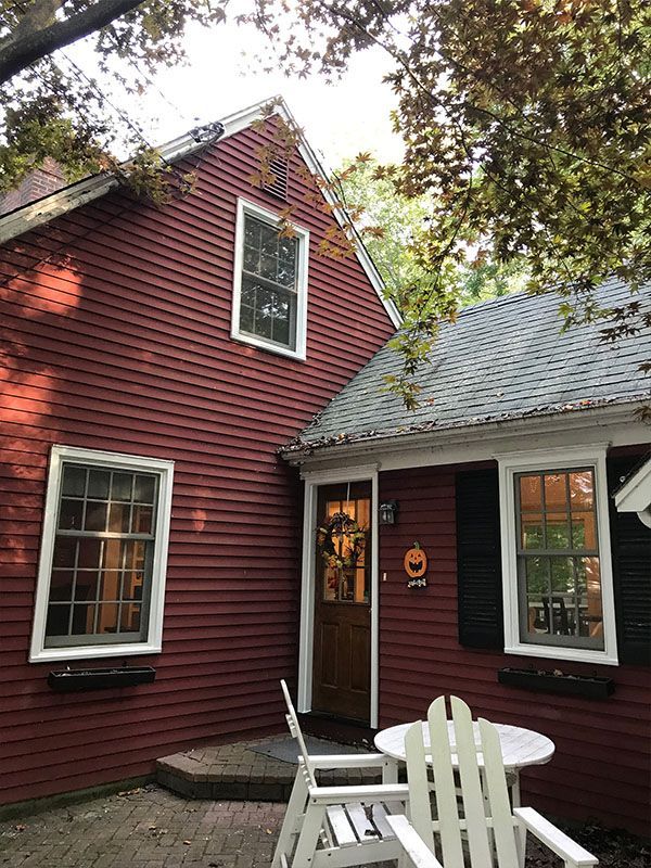 A red house with a table and chairs in front of it.