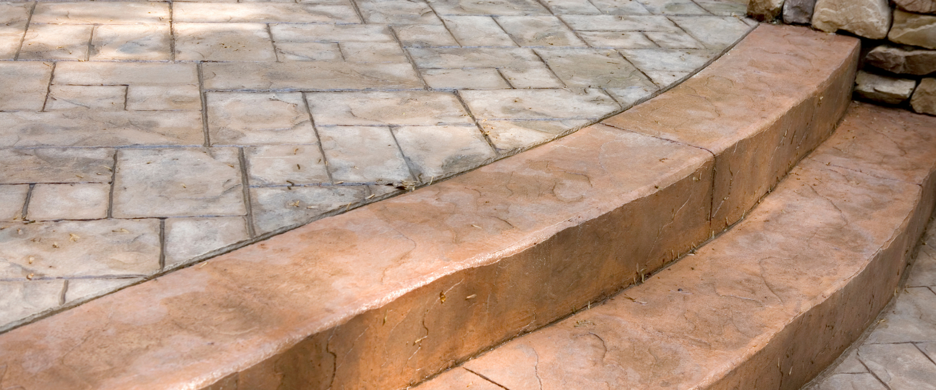 A set of stairs leading up to a stone patio.
