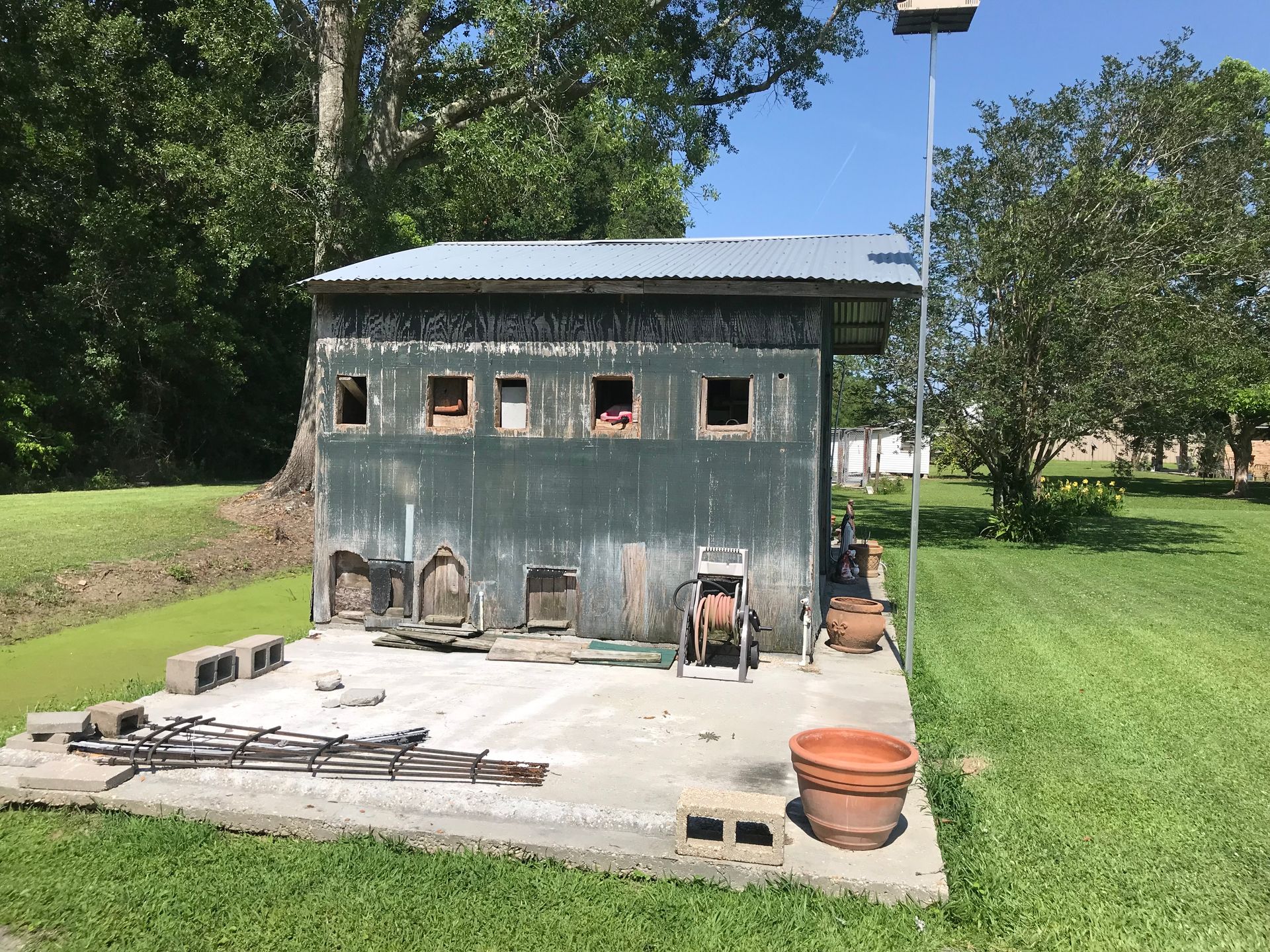 A shed is sitting in the middle of a grassy field