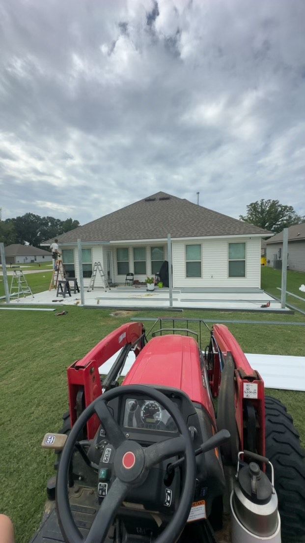 A red tractor is parked in front of a house.
