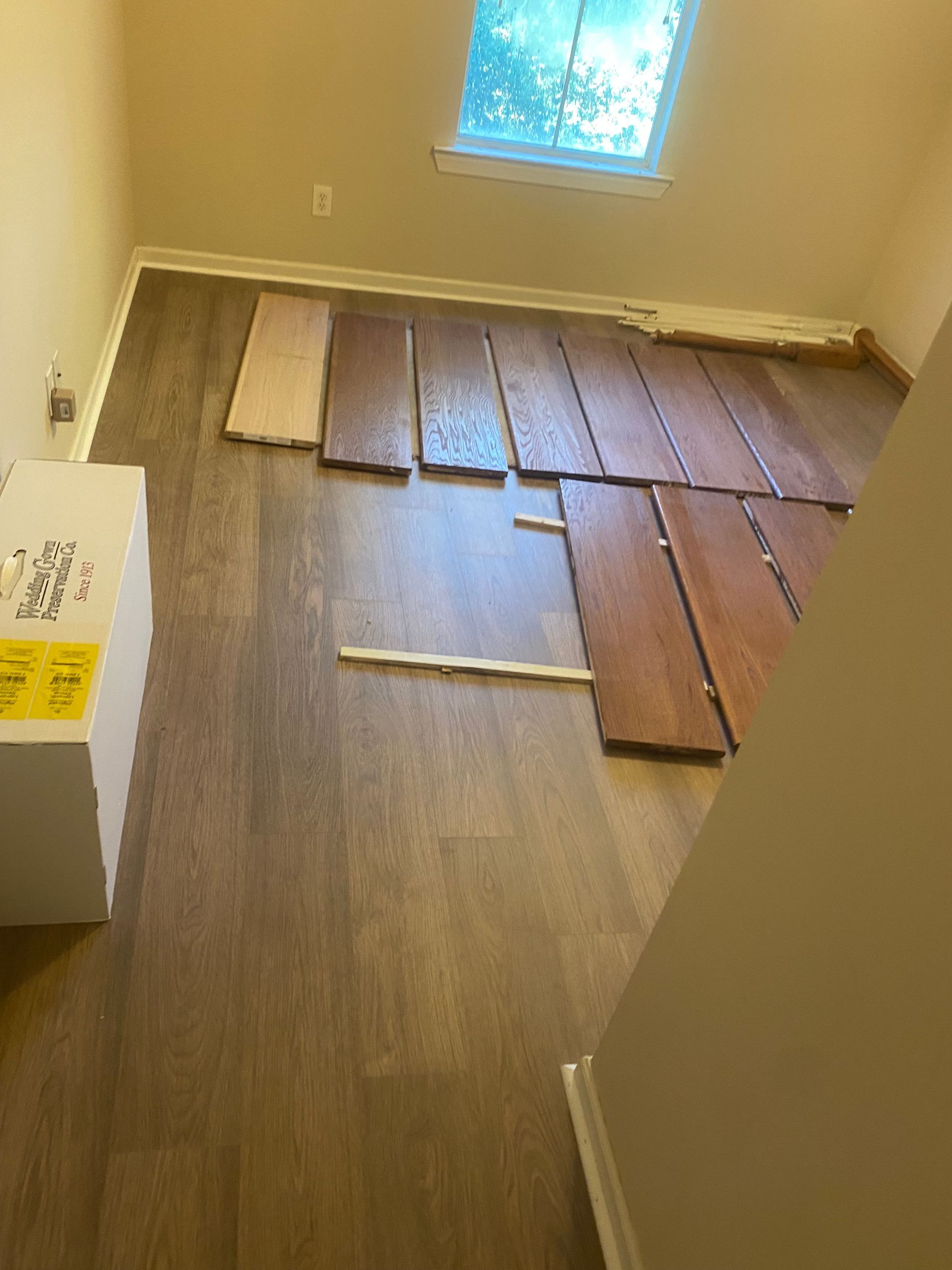 A room with a lot of wooden floors and a window.