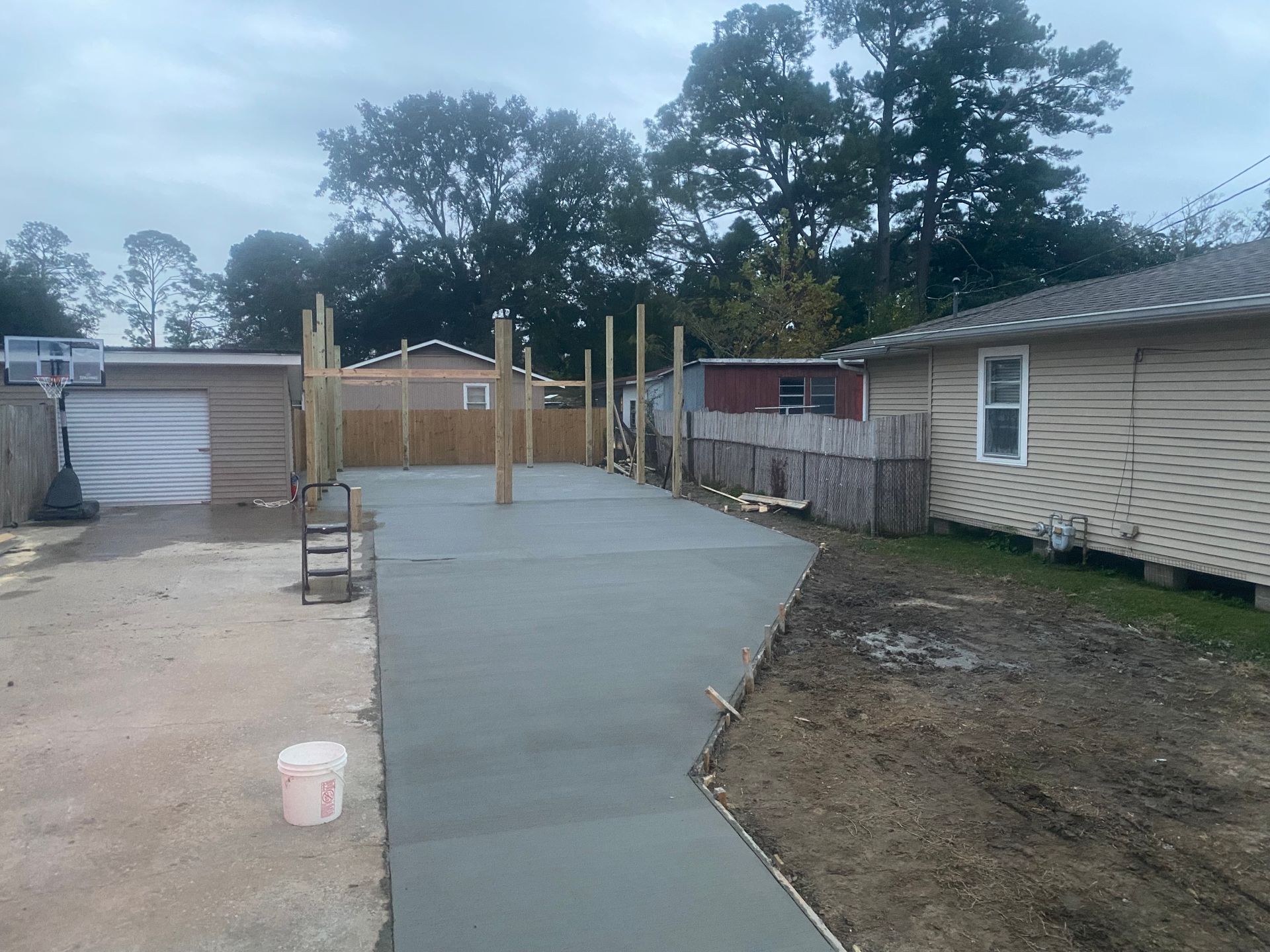 A concrete driveway is being built in front of a house.