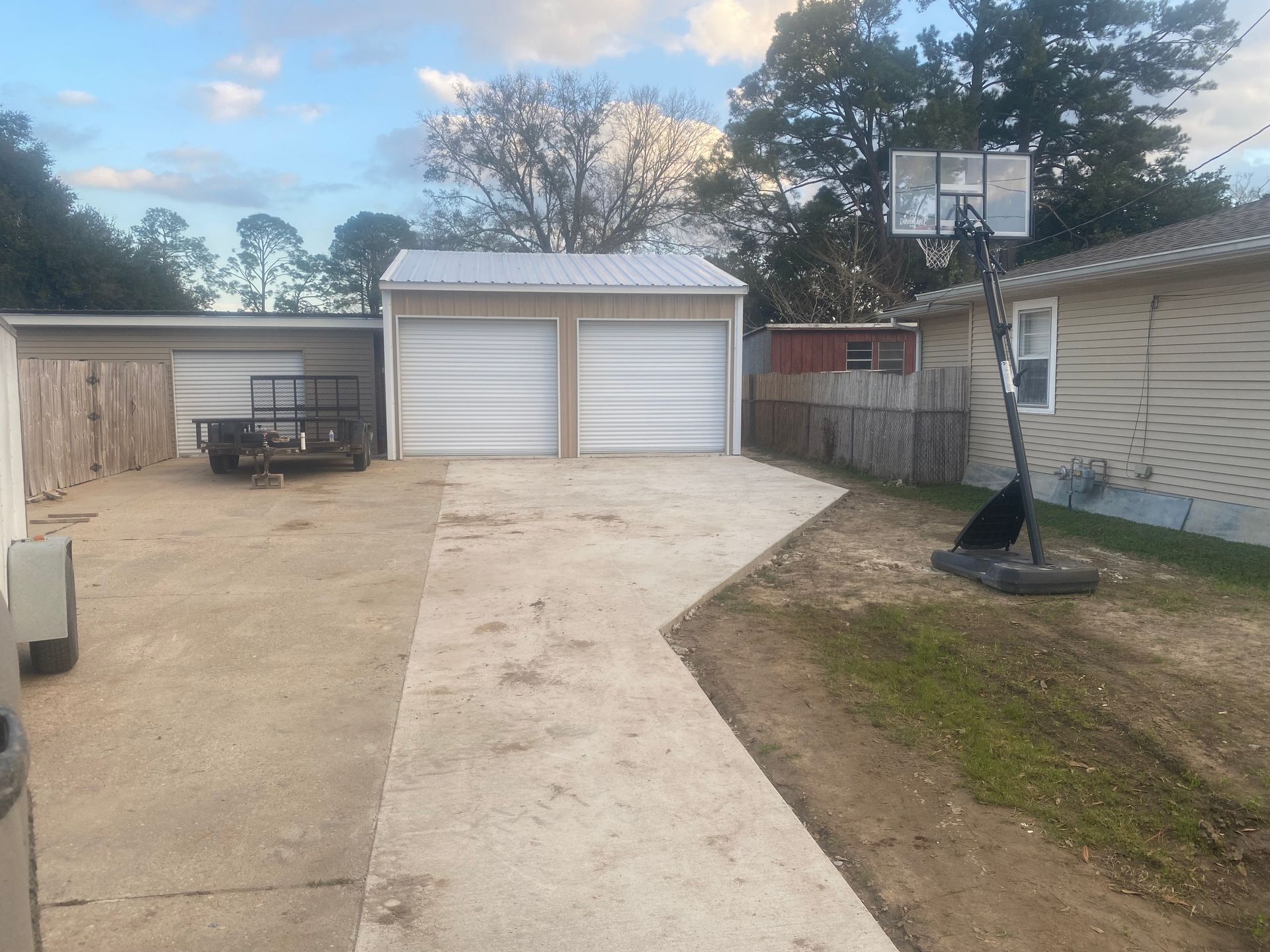 There is a basketball hoop in the backyard of a house.