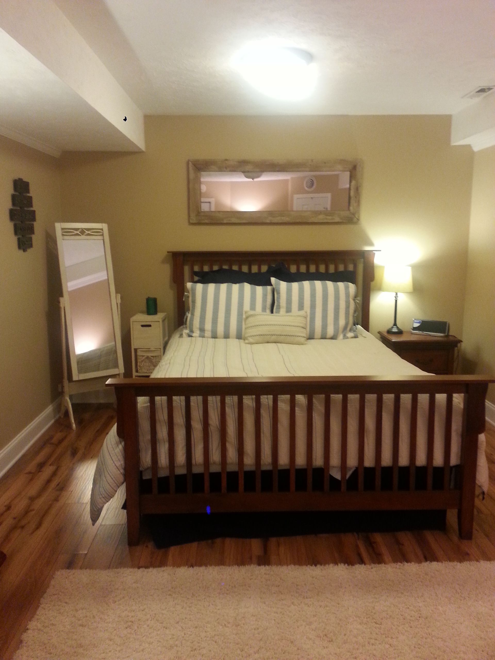 A bedroom with a king size bed and striped pillows
