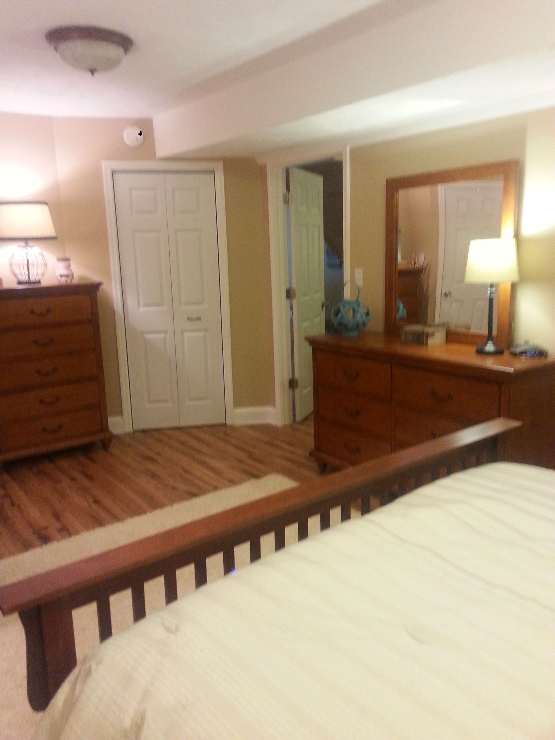 A bedroom with a bed dresser and mirror