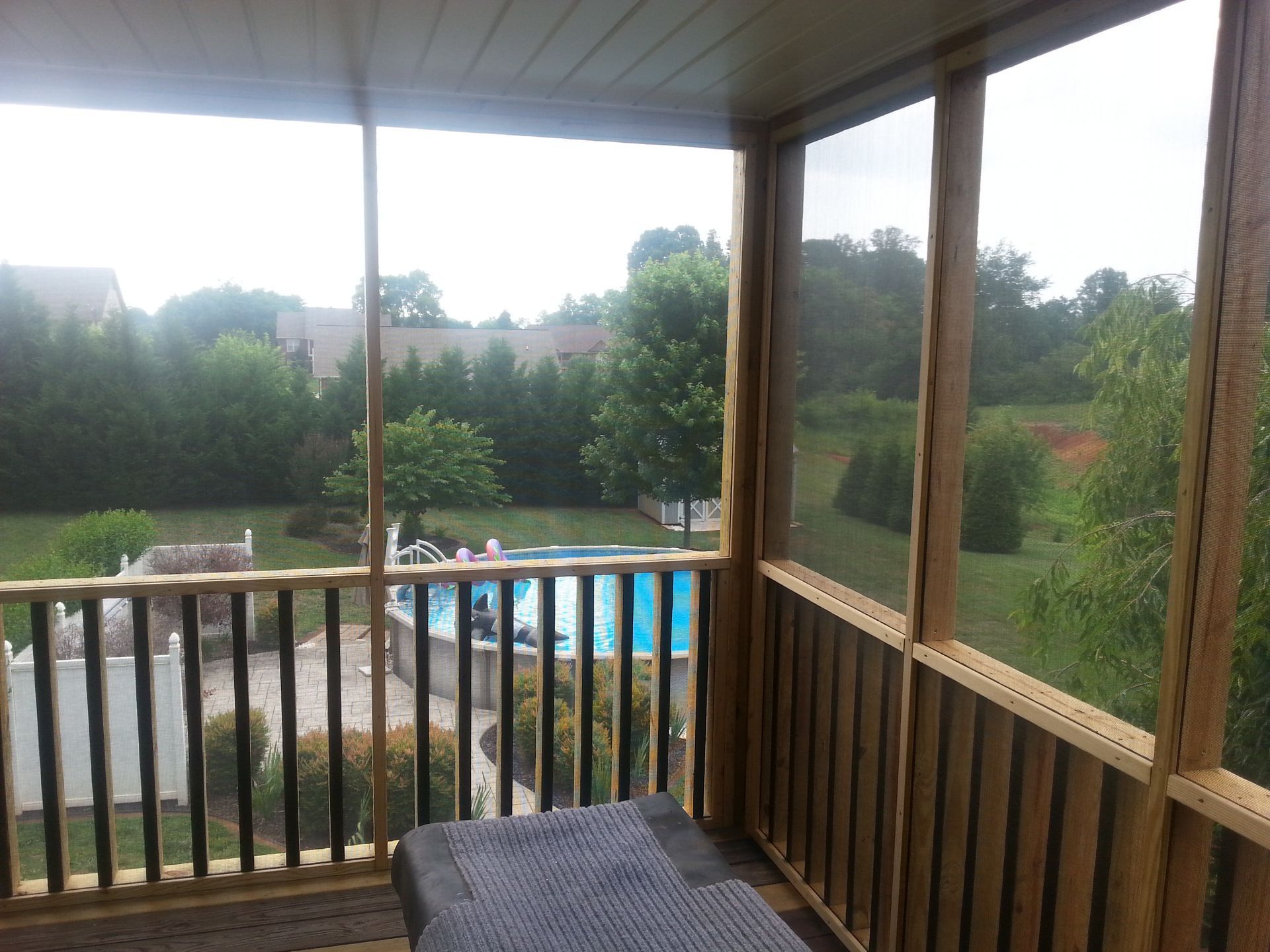 A screened in porch with a view of a swimming pool