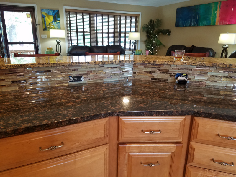 A kitchen with a granite counter top and wooden cabinets