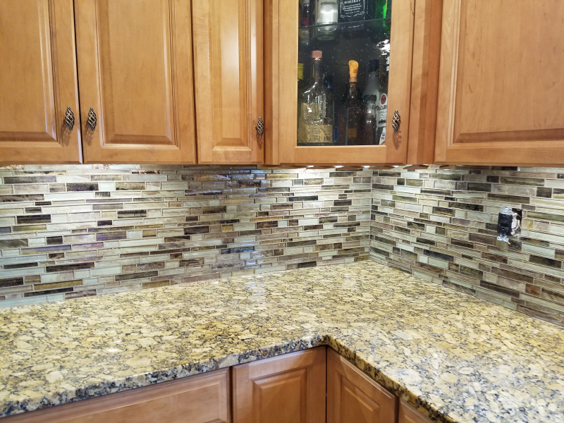 A kitchen with wooden cabinets and granite counter tops.