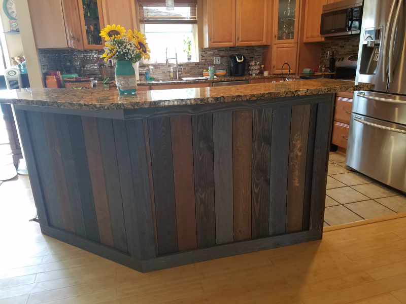 A kitchen with a wooden island and a stainless steel refrigerator.