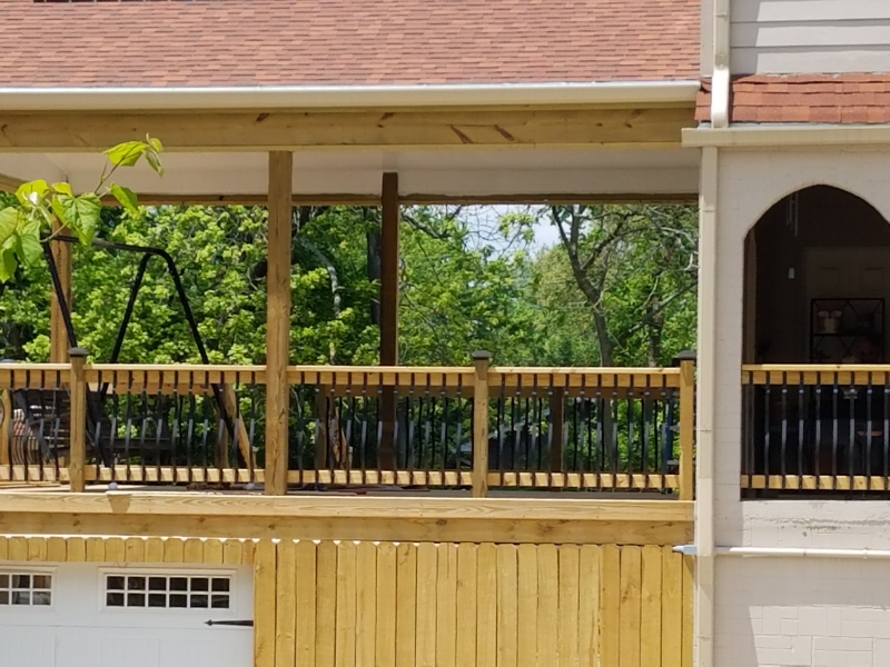 A house with a wooden deck and a white garage door