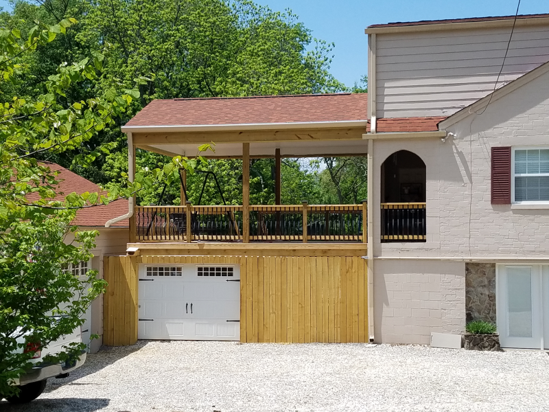 A house with a wooden deck over a garage