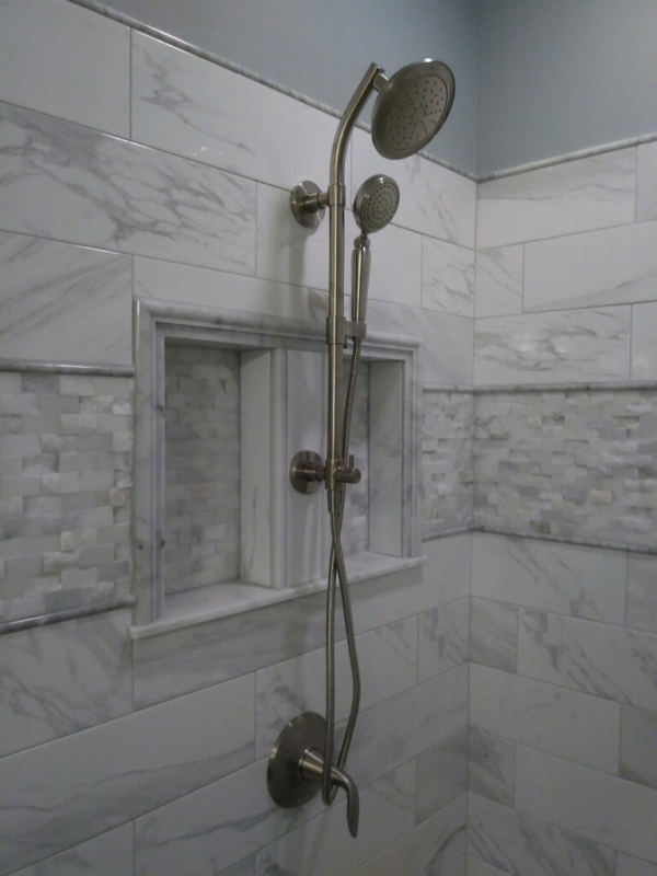 A shower head is hanging from the wall in a bathroom.
