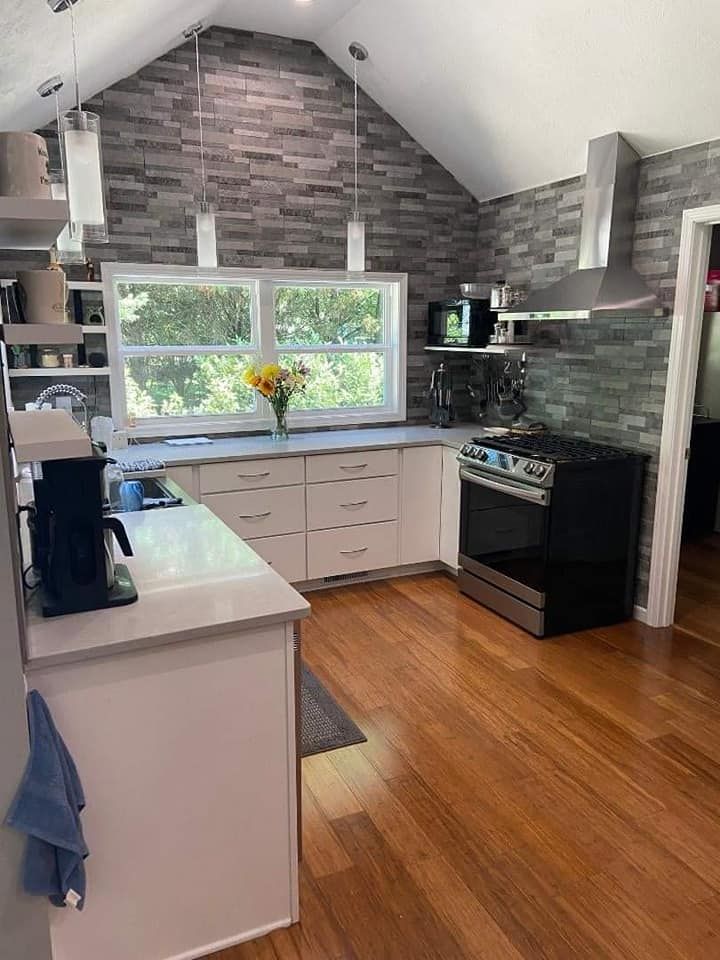 A kitchen with a vaulted ceiling and hardwood floors