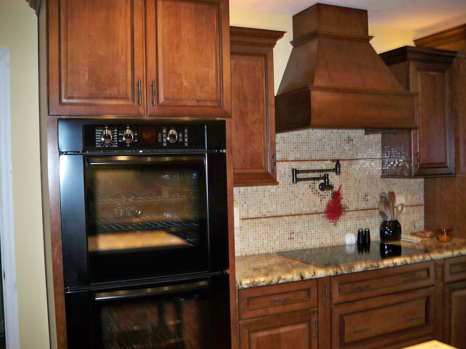 A kitchen with wooden cabinets and a black oven