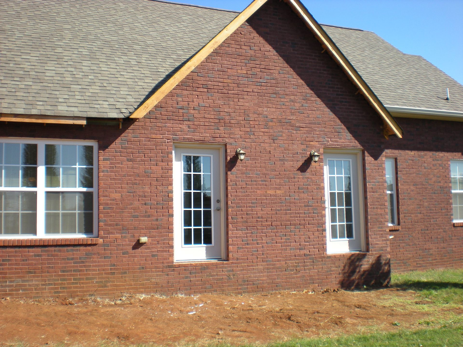 A brick house with white windows and a gray roof