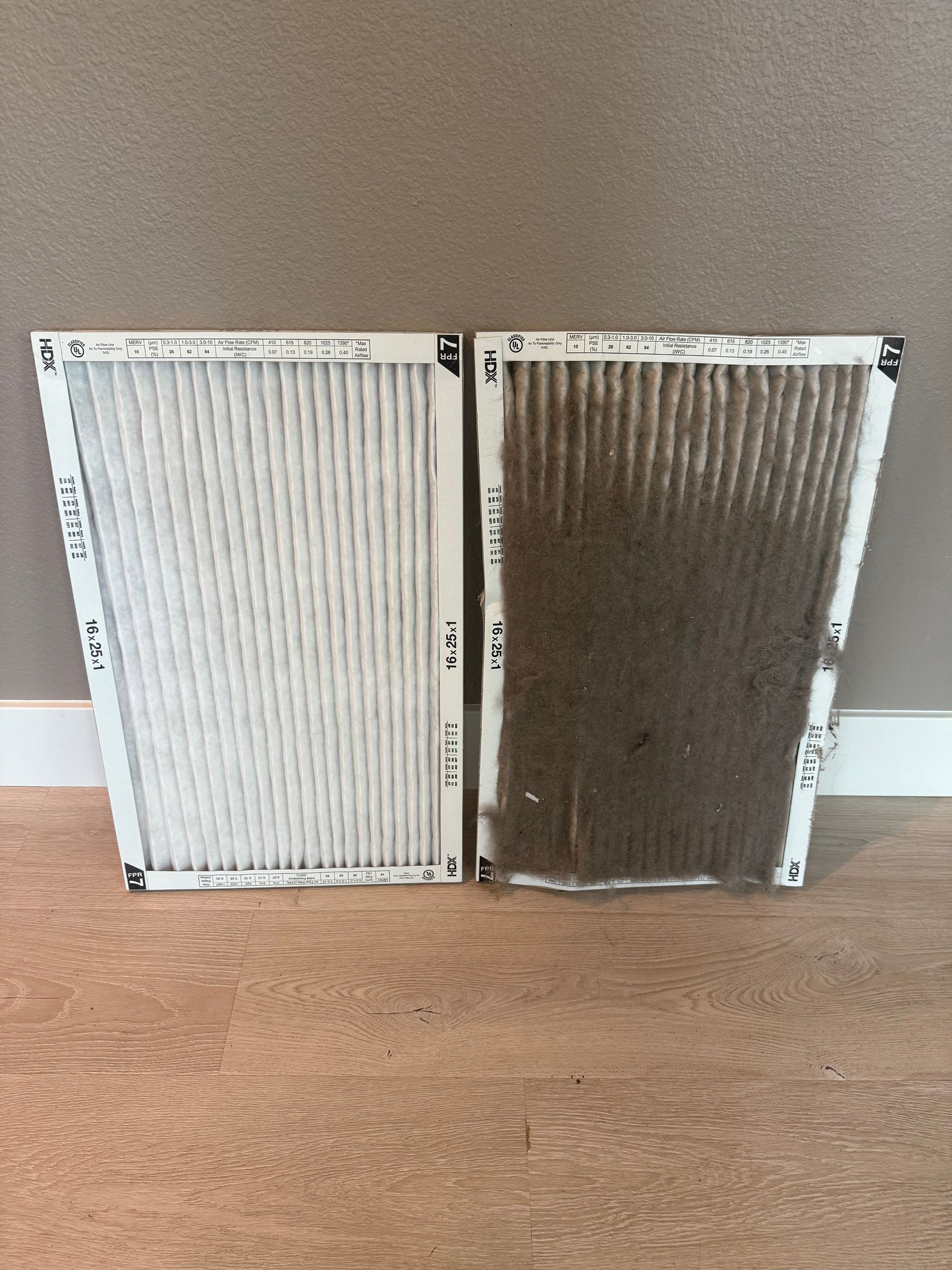 Two air filters, one clean and white, the other very dirty and brown.