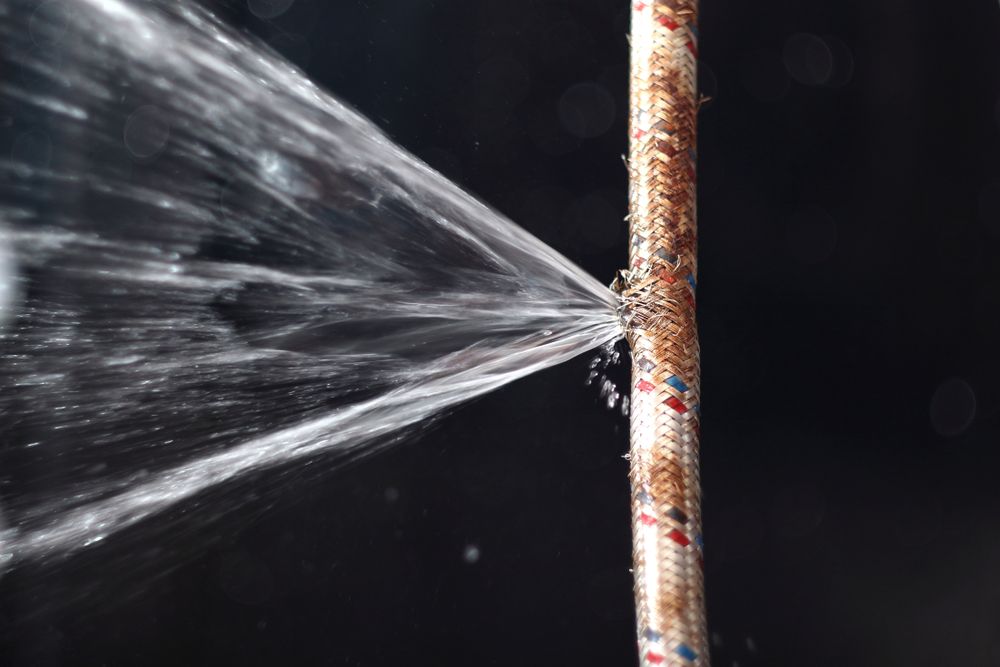 A Close Up of a Rusty Pipe With Water Spraying Out of It — Subat Plumbing Services in Maitland, NSW