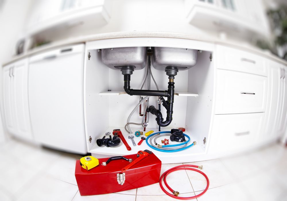 A Kitchen Sink is Being Repaired by a Plumber — Subat Plumbing Services in Kurri Kurri, NSW