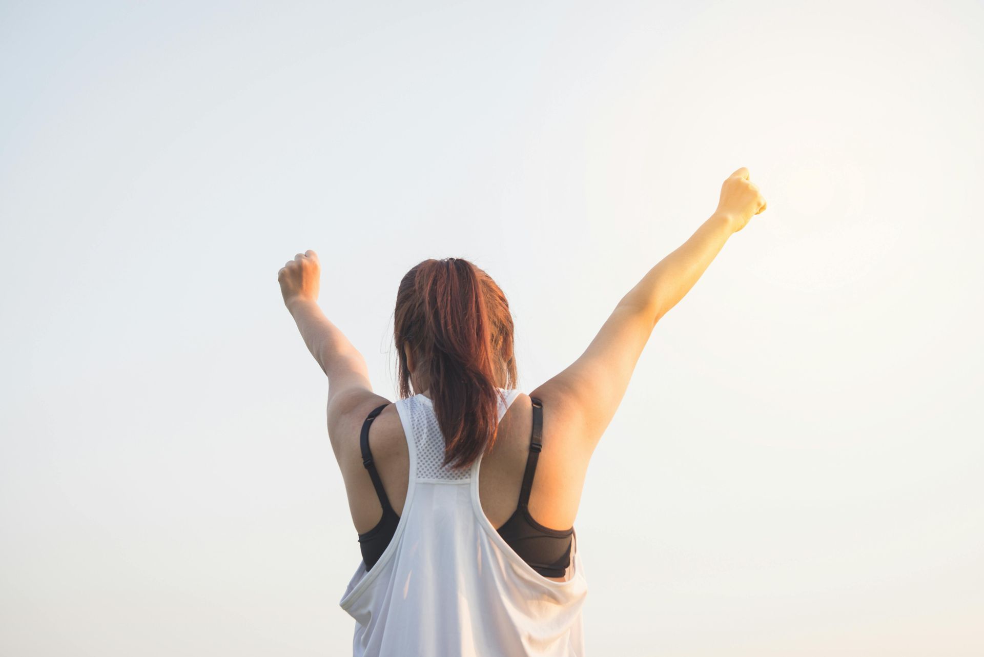 A woman is standing with her arms outstretched in the air.