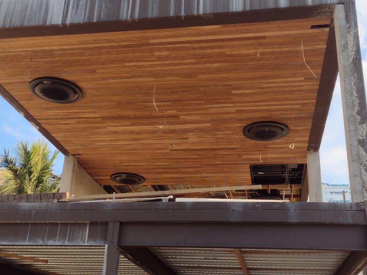 Parte inferior de uma cobertura de madeira com três aberturas de ventilação circulares. Canteiro de obras.