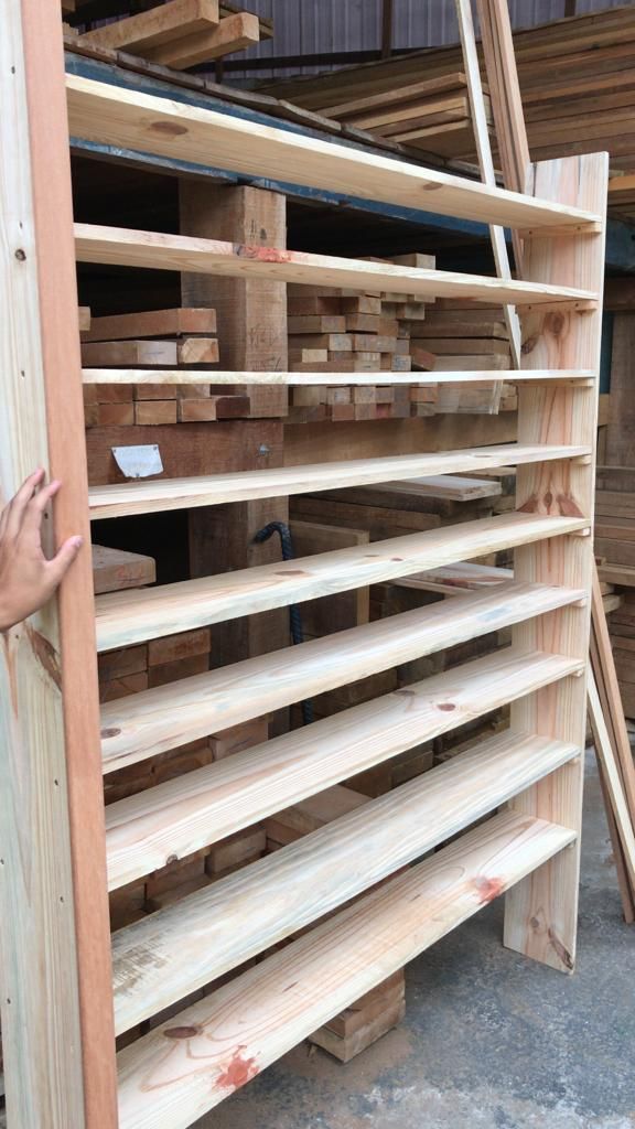 Estante de madeira contendo diversas tábuas de madeira em um depósito de madeira.