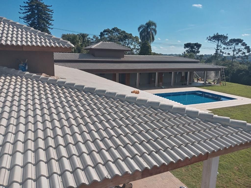 Telhado de telha de uma casa com piscina, em um dia ensolarado.