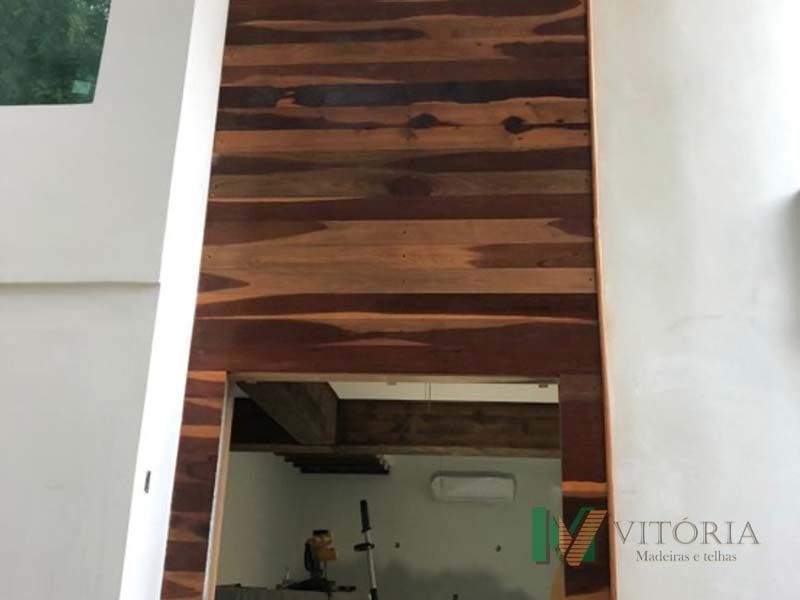 Painéis de madeira emolduram uma abertura em uma parede branca.