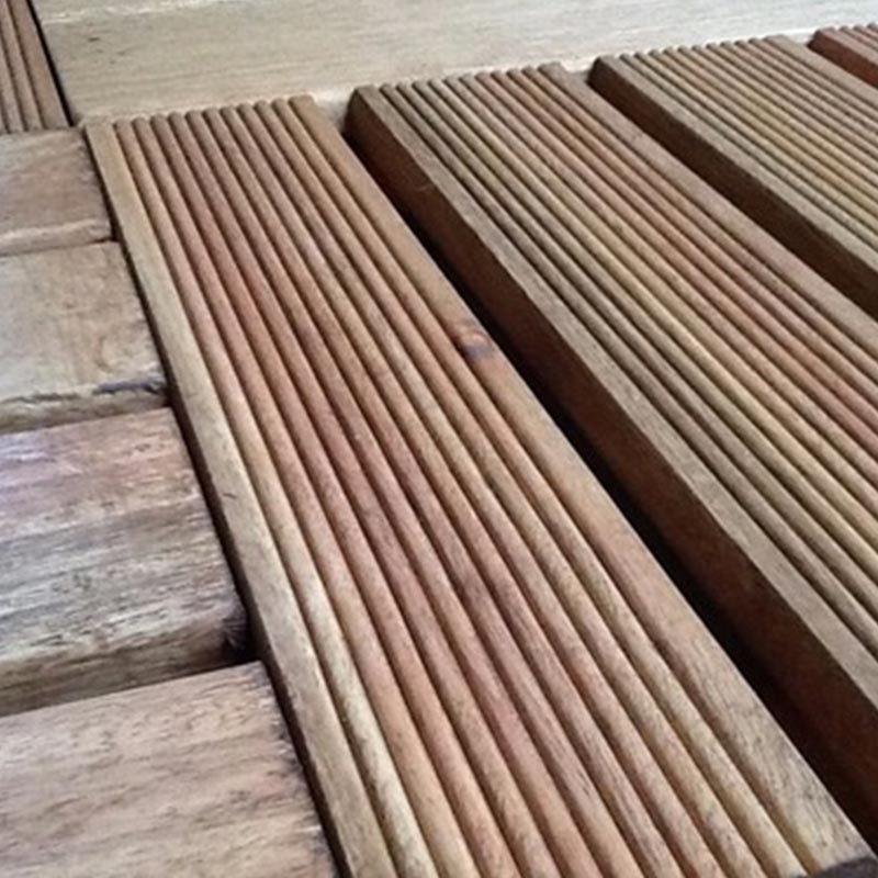 Tábuas de deck de madeira com superfícies ranhuradas, em tons de marrom.