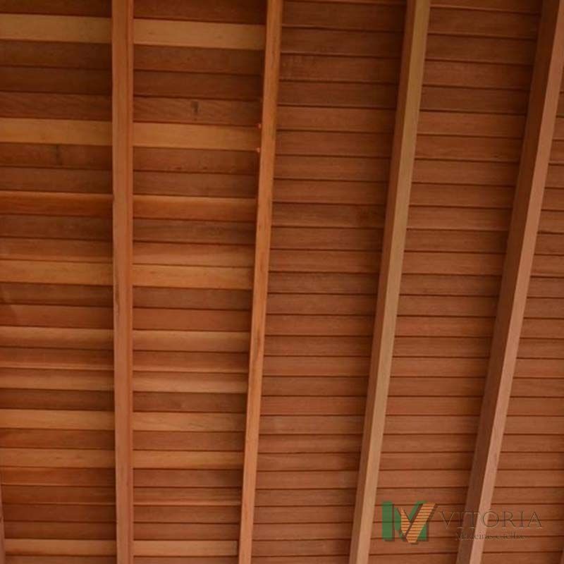 Teto de madeira com tábuas horizontais e vigas de sustentação diagonais.