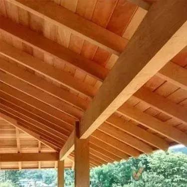 Teto de madeira com vigas e caibros aparentes.