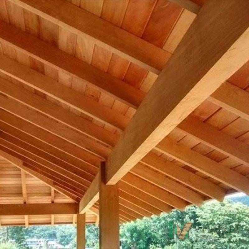 Telhado de madeira no pátio com vigas e tábuas expostas, iluminação natural.