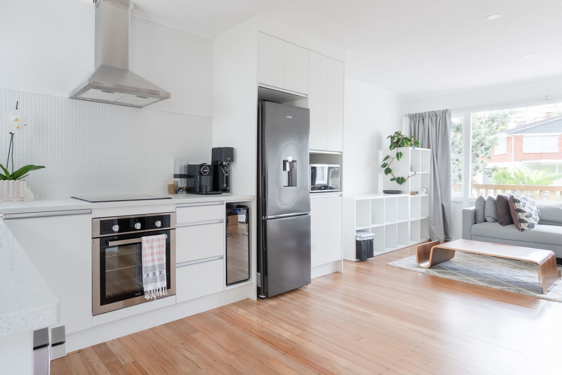 A kitchen with white cabinets , stainless steel appliances , a refrigerator and a stove.