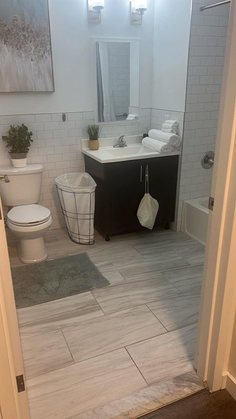 A bathroom with a toilet , sink , and shower.