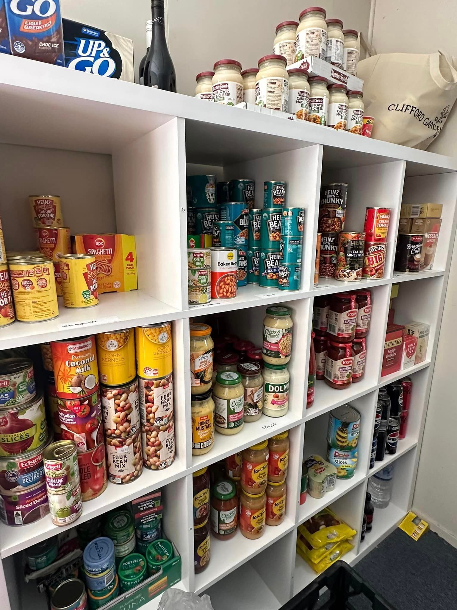 A shelf filled with lots of cans and jars of food.