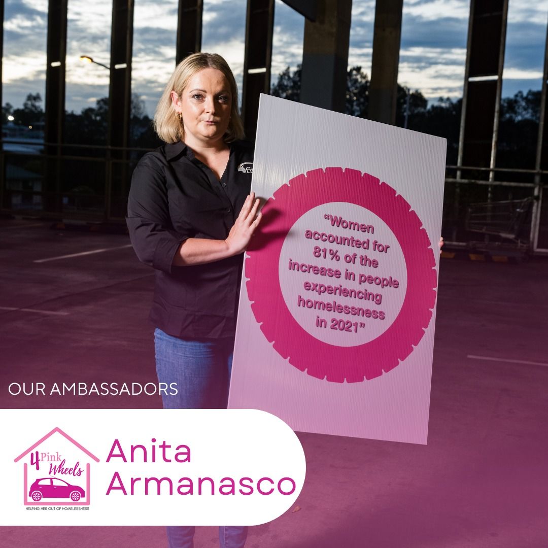 A woman holding a sign that says anita armanasco