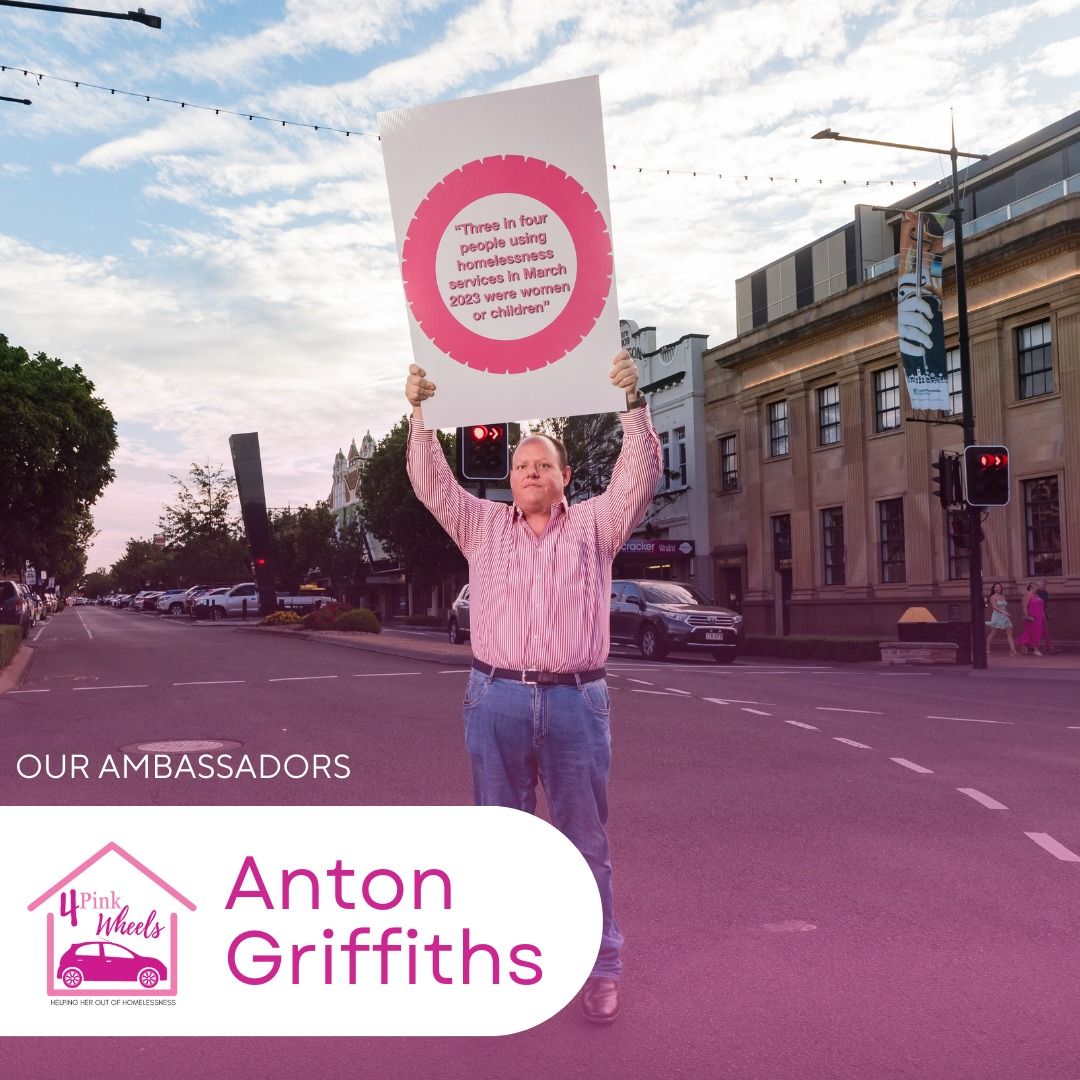 A man is holding up a sign that says anton griffiths