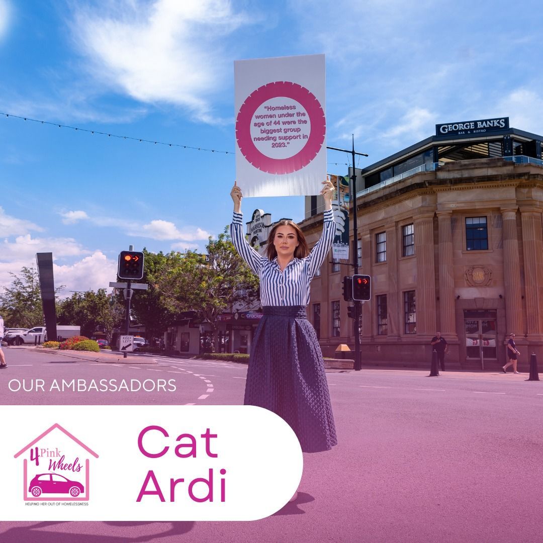 A woman is holding up a sign that says cat ardi