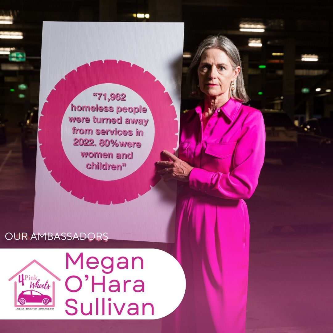 A woman in a pink dress is holding a sign that says megan o'hara sullivan
