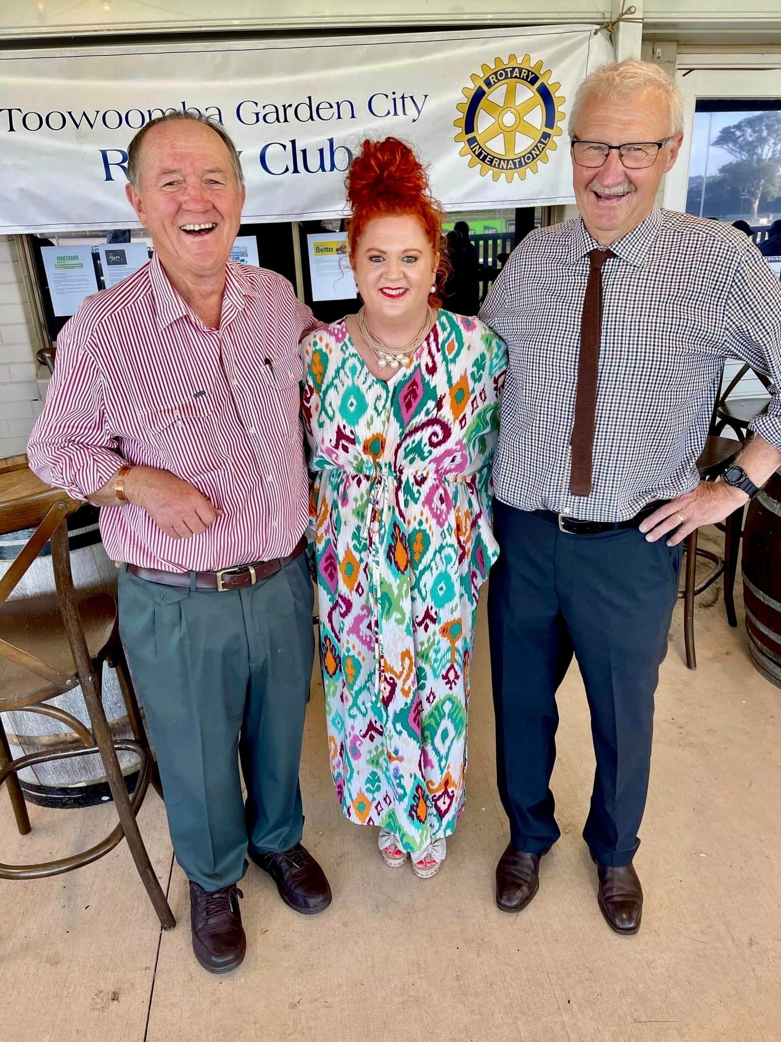 Three men and a woman are posing for a picture in a room.