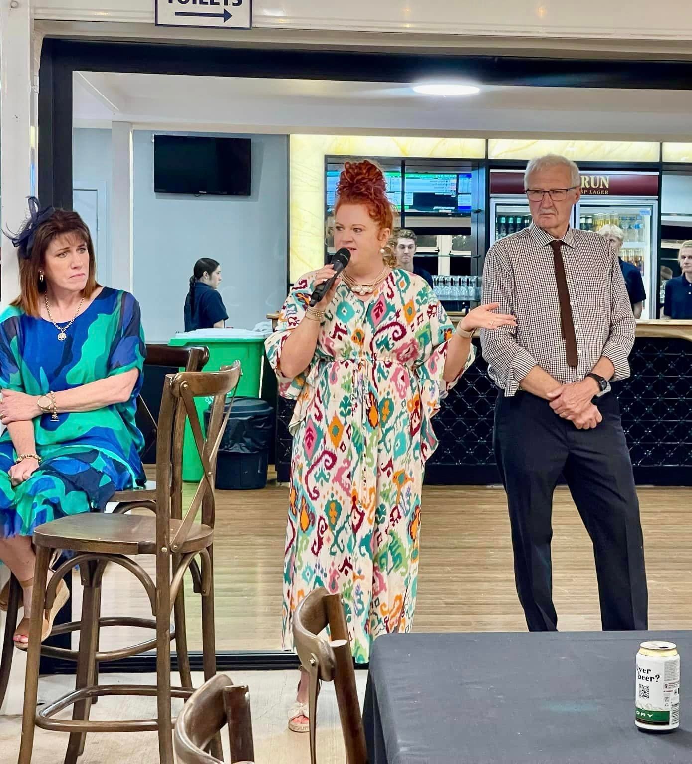 A group of people are standing around a table in a restaurant.