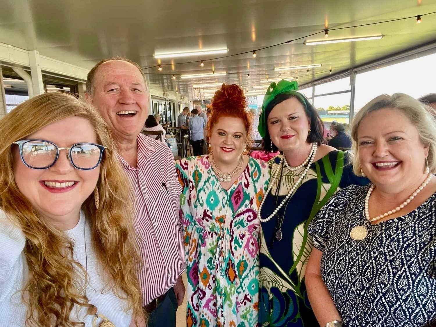 A group of people are posing for a picture together and smiling.