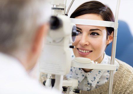 Woman Look in Ophthalmoscope - Eye Exams in Idaho Falls, ID