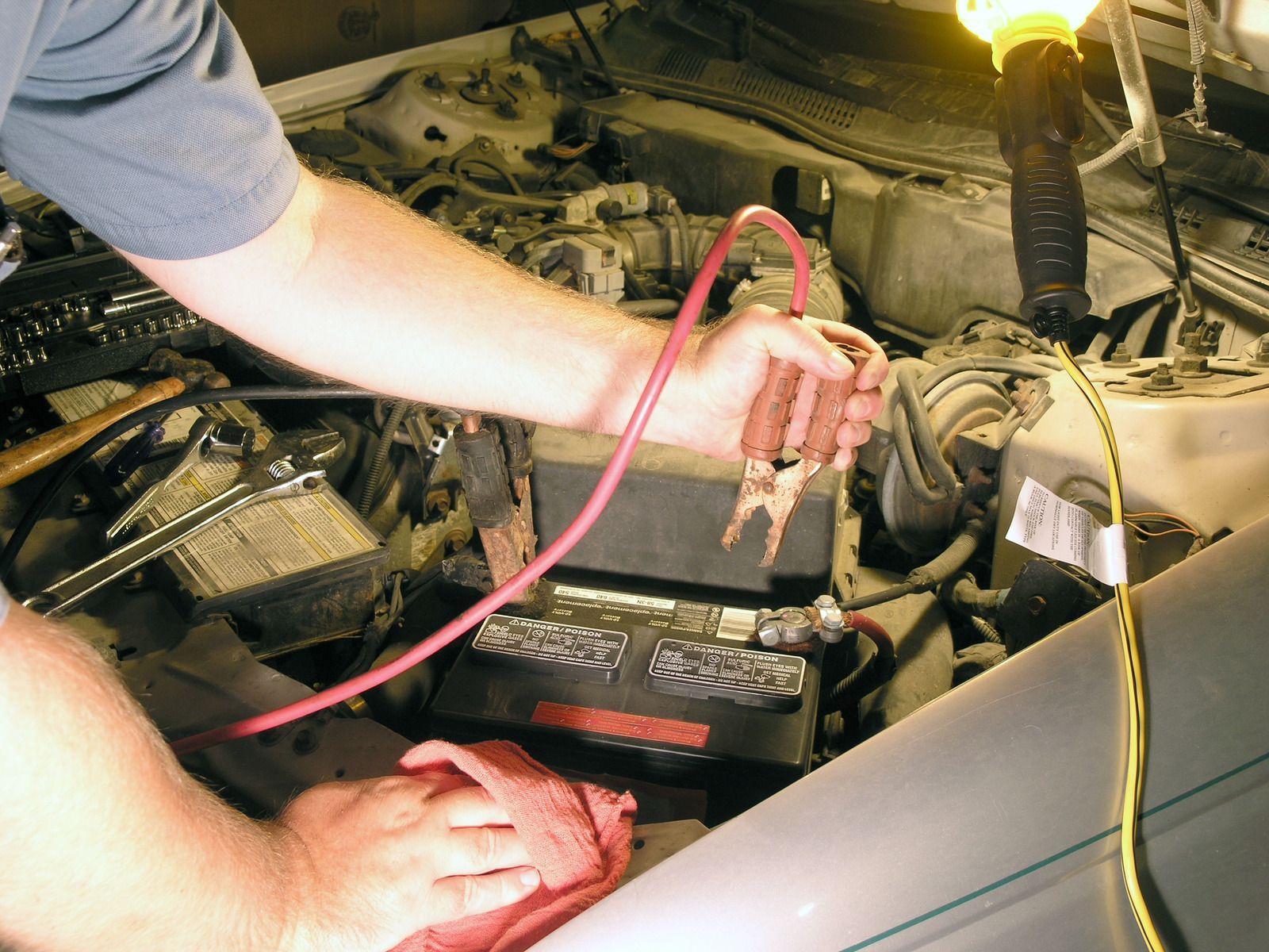 A man is working under the hood of a car