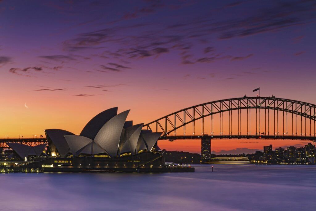 Sydney Harbour Bridge at sunset, with the Sydney Opera House in the foreground